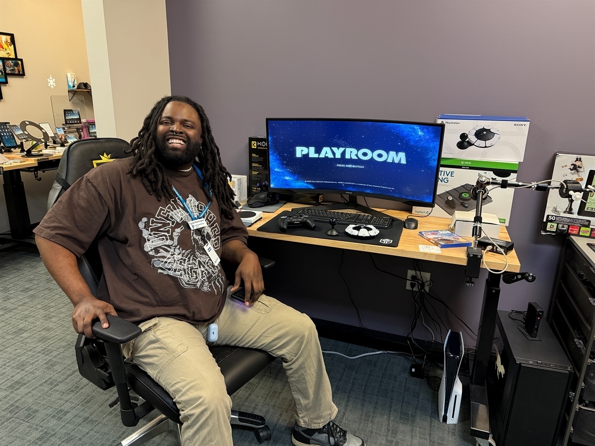 Cortez Washington smiling in front of gaming equipment