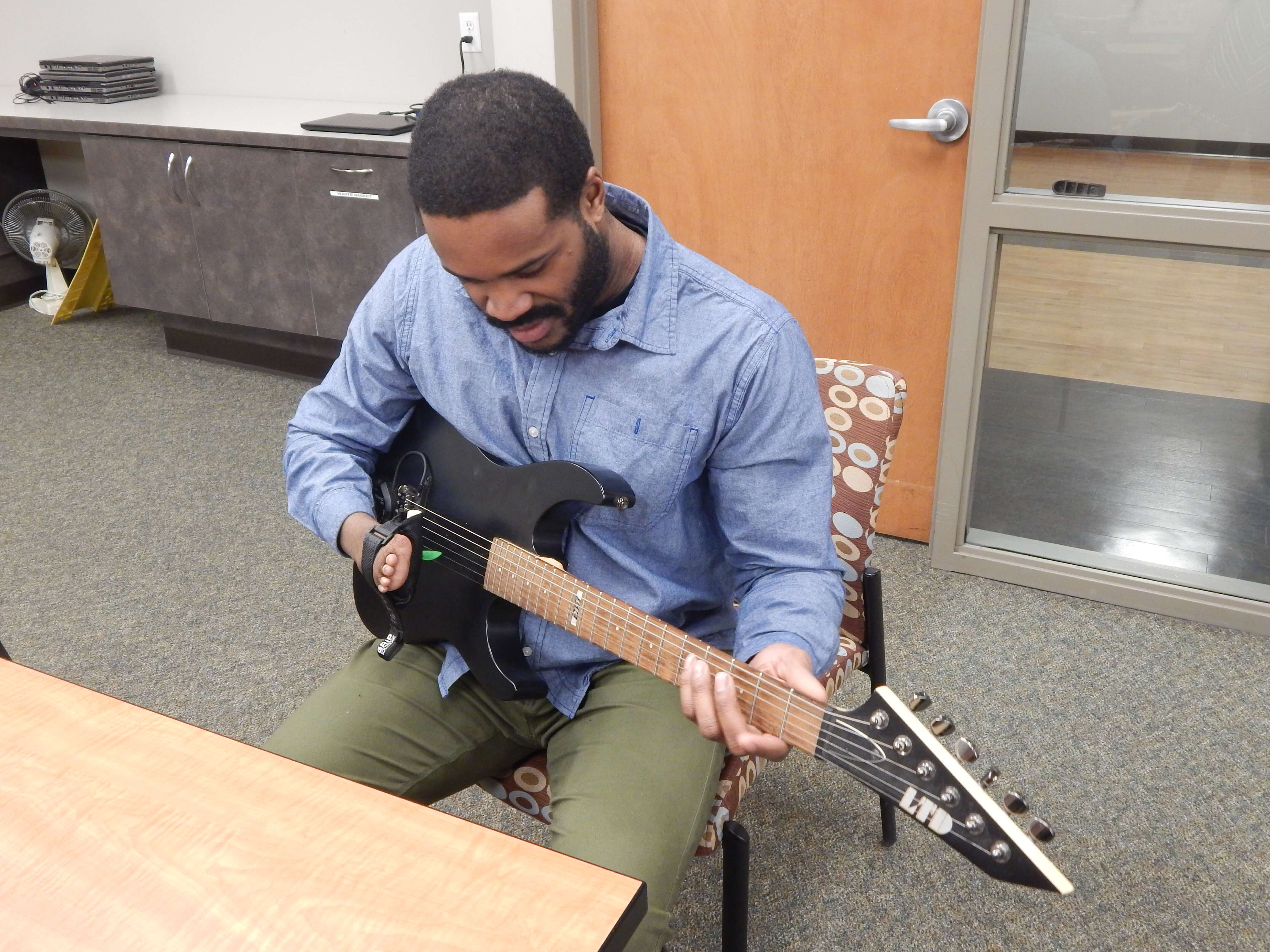 Man with limb difference plays guitar