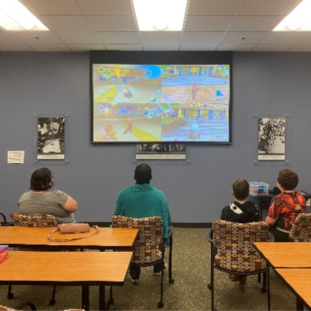 Participants at game night play an adaptive video game